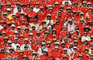 E na sexta-feira, um mar de camisas vermelhas e chapéus de balde com as cores do arco-íris encheu o estádio enquanto os torcedores galeses assistiam seu time perder por 2 a 0 para o Irã.