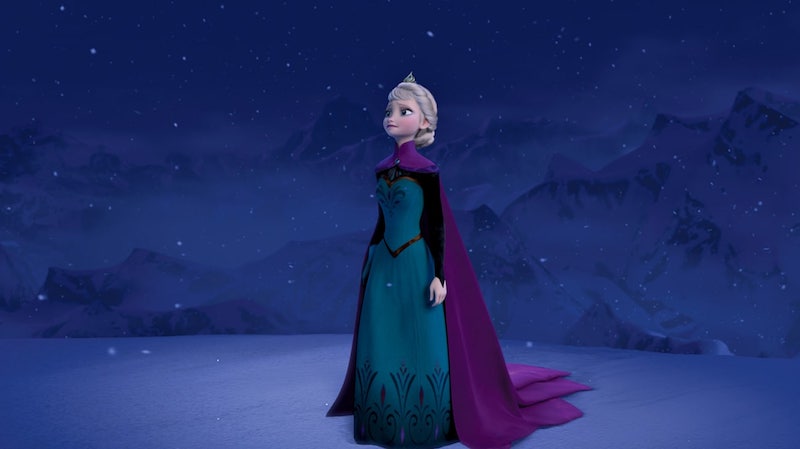 Elsa in dress, cloak, and tiara standing in a stark, icy setting as it snows