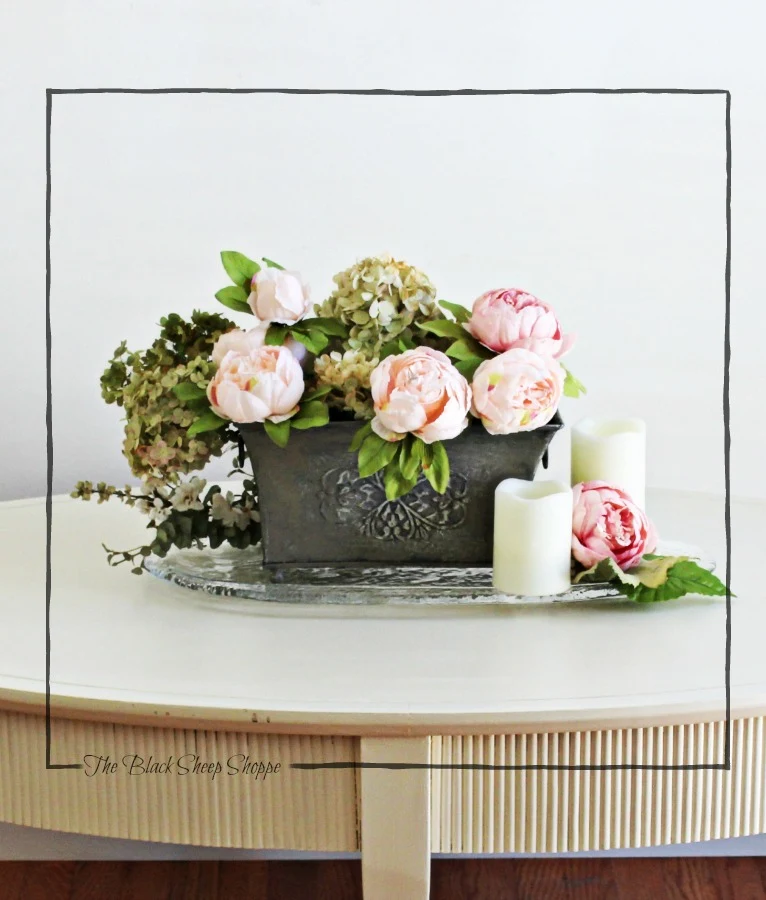Centerpiece of peonies and hydrangeas on coffee table.