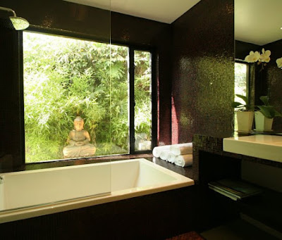 Zen inspired master bathrooom after The Sunset Team/La Kaza Design's remodeling with mosaic tiles covering the walls, bath and vanity area, a picture window with a view of a bamboo garden and a Buddha statue