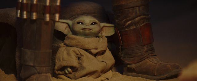 Baby Yoda Grogu Sits Between The Mandalorian's Legs Disney Plus