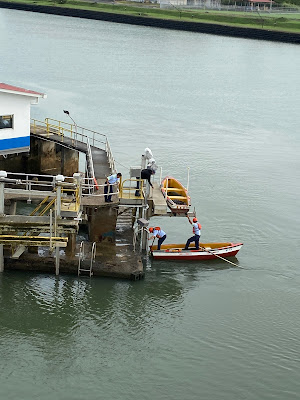 row bow workers getting ready to tie up cruise ship in The Panama Canal