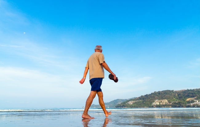 Uomo che cammina in riva al mare