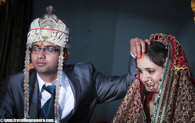 Var Mala ceremony is an important main wedding day ceremony. It is also known as Jaimala and basically involves exchange of garlands between the bride and the groom. Like all other customs and rituals, this is also a significant ceremony which finds reference even in the Vedic literature. It is an ancient practice and is still observed in India. fter Varmala Ceremony, both of the main parties need to sit on hot seats to have good wishes of their relatives and loved ones !!!And of course, need to practice a smile which comes consistently with each photograph of relatives behind these seats...Friends plays important role in a marriage and is a good support when you have handle with bride's sisters/friends :)SaptapadiOne of the most significant rituals the bride and the groom perform is the Saptapadi or saat phere around a scared fire that is symbolic of God. One end of the groom's scarf is tied to the bride's dress and this marriage knot is supposed to symbolize a life-long togetherness. Then they take seven rounds around the fire and each of these rounds represents nourishment, strength, prosperity, happiness, progeny, long life and harmony and understanding, respectively. It is also during this time that the groom fills vermillion or sindoor in the center parting of the bride and puts mangalsutra around her neck.This process of adding vermillion or sindoor takes place thrice and of course it's very difficult to control the amount of sindur being placed each time... Gorgeous smile after one of the main ceremony of Himachali Marriage - Sindoor !!