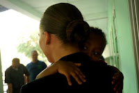 Engineering Aid 2nd Class Susan Knox holds a child at Saint Francis Notre Dame Orphanage in Djibouti, June 26, while troops donated shoes and toys to local orphans.