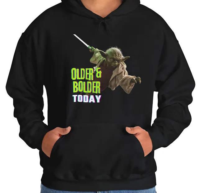 A Hoodie With Star Wars Yoda Flying Having Blade in Hand and Caption Older and Bolder Today