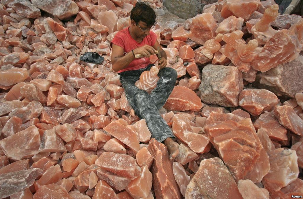 A man in Lahore applies the final touches to a sculpture made from rock salt. 