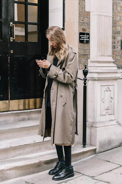 A woman wore a gray trench coat.