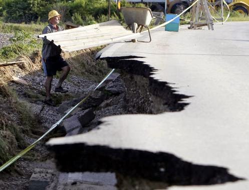 These 16 photos will disturb you... The Balkans in the grip of flood! - A man is seen next to a damaged road as he collects building materials after heavy floods in Bosanski Samac May 19, 2014.