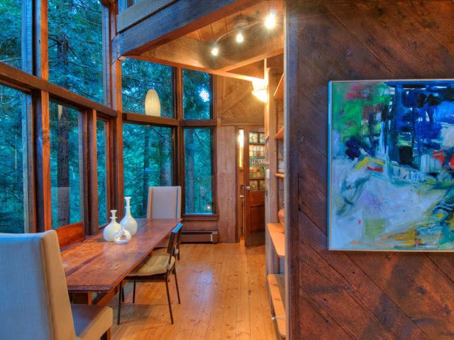 Photo of hallway and small dinning table inside of tree house in the forest
