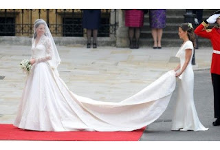 Kate Middleton in her wedding dress with her sister Pippa Middleton holding the train.