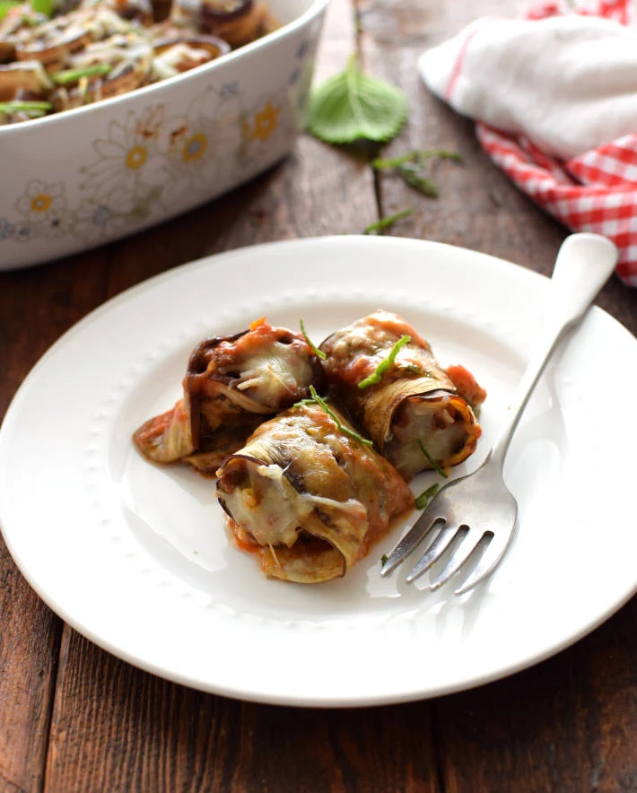 Porción de rollitos de berenjena servidos en un plato, listos para degustar