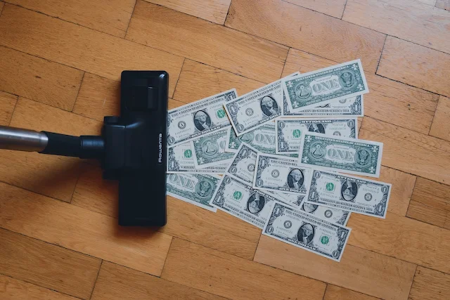 Vacuum cleaner vacuuming up dollar bills to represent revenue leakage