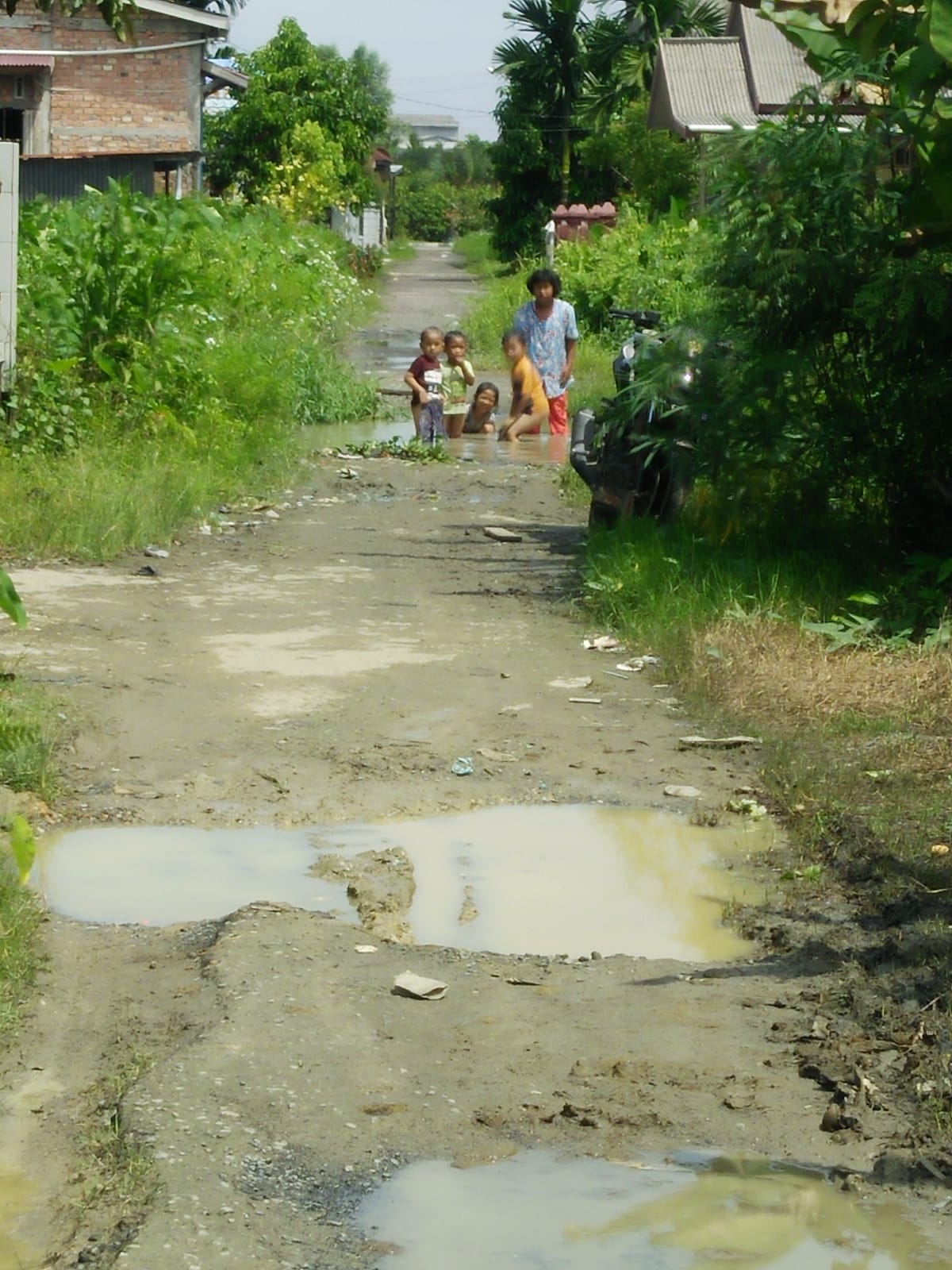 Jalan Rusak Berlobang yang Digenangi Air Jadi Permainan Anak, Warga Minta Perbaikan Serius