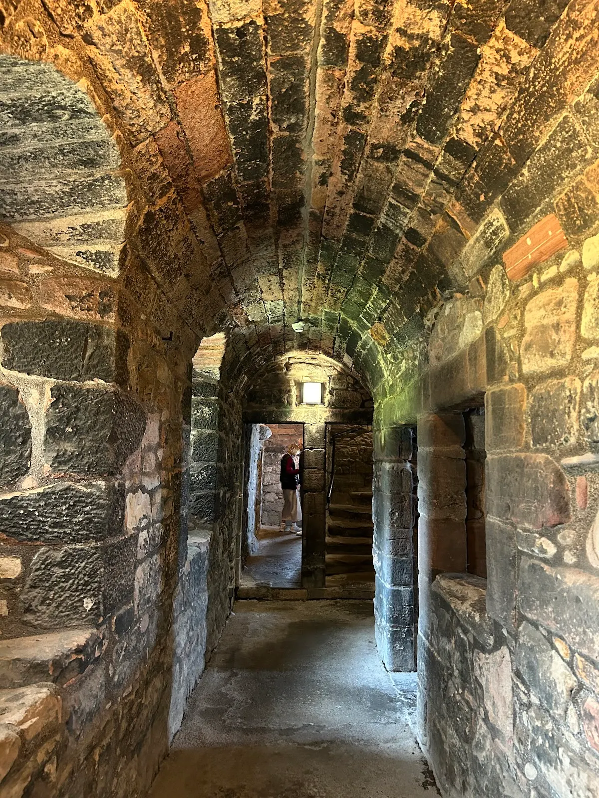 Tourist standing on a viewing platform inside Newark Castle, looking out over the river.