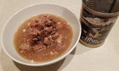 A rather unappetizing bowl of watery broth with canned beef chunks in it