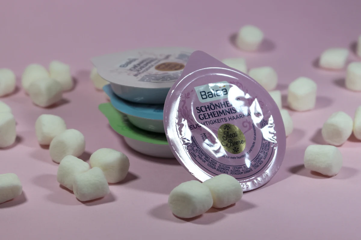 small capsule with hair care mask by balea on a pink studio's background