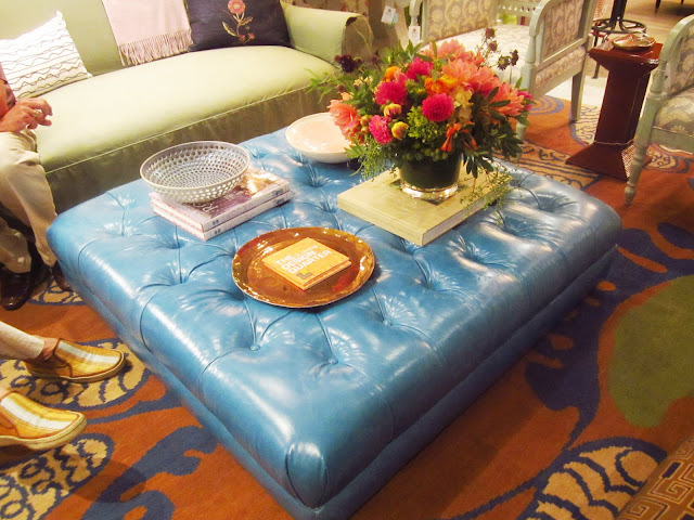 turquoise leather square ottoman being used as a coffeetable