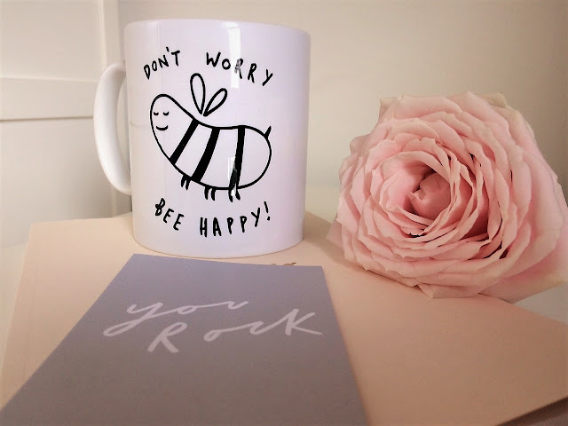 Mug reading 'Don't Worry Bee Happy' with smiling bee next to pink peony