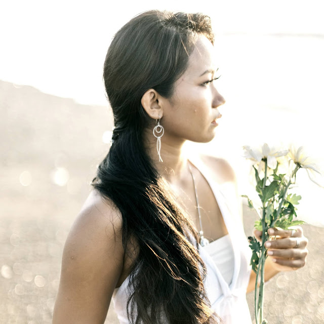 Woman holding flowers walking on the beach