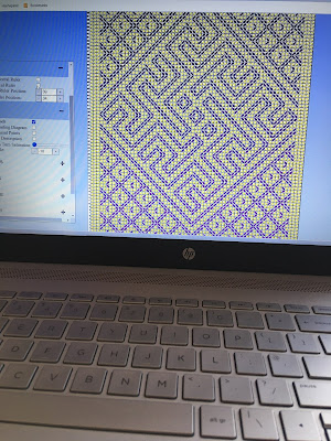 A photo of a laptop screen showing Tablet Weaving Draft Designer draft in purple and yellow, with the threads turned on and the backward turn saturation set to zero