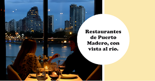 Una pareja disfrutando de una cena en un restaurante de Puerto Madero, con vista al río.