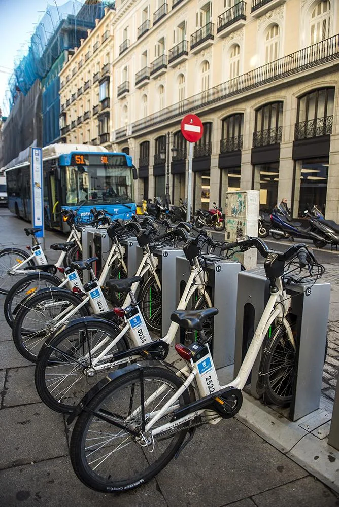 Bus urbano circulando al lado de un aparcamento de bicicletas - Instalaciones eléctricas residenciales