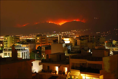 Caption: Athenians watch the huge fire burning the thick forest on Mount Parnitha, some 20 km away from Athens, on Friday, 29 June 2007. The Mont Parnes hotel casino on the peak and camping sites have been evacuated. ANA-MPA/SIMELA PANTZARTZI