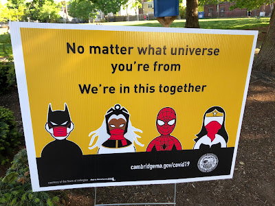 Batman, Storm, Spider-Man and Wonder Women wearing face masks below the words "No matter what universe you're from we're in this together"