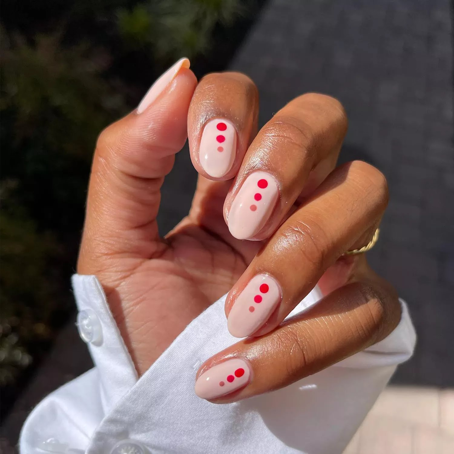 Short peach nails with three dots down the middle