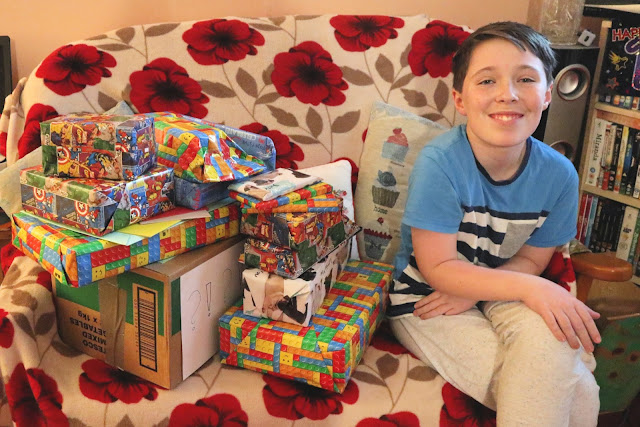 Teenager sitting next to a pile of birthday presents