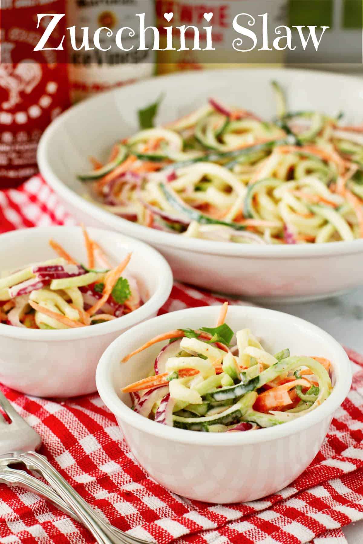 Zucchini Slaw in two small bowls in front of a serving bowl.
