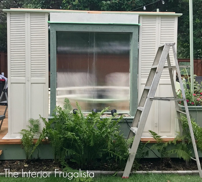A budget-friendly Deck Privacy Screen idea made with repurposed wooden louvered bifold doors where you can see out but the neighbors can't see in!