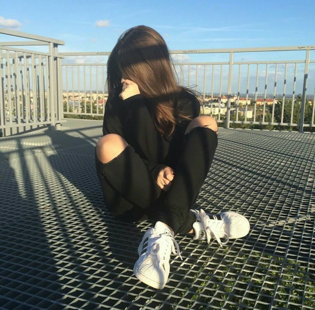 Foto tumblr chica sentada en el suelo tapandose la cara outfit negro con cielo de fondo