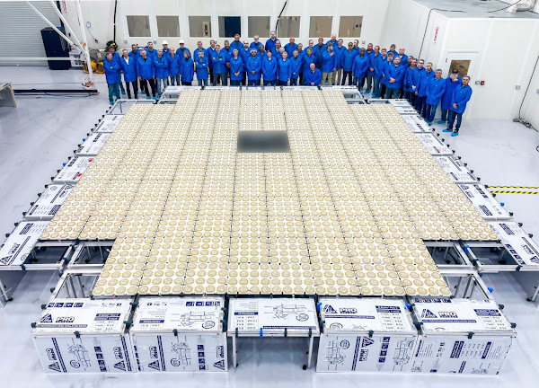 AST SpaceMobile's BlueWalker 3 test satellite on the floor in a hall with a group of scientists in the background