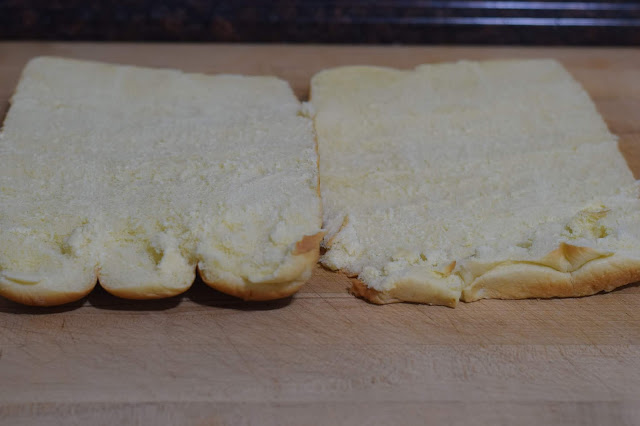 The sweet Hawaiian rolls, cut in half, on a cutting board. 