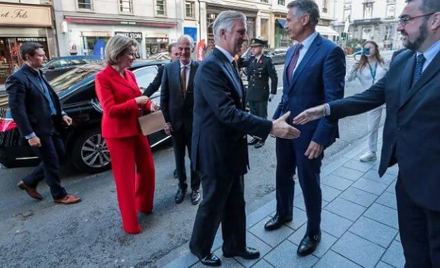 Queen Mathilde wore a red double breasted blazer by Armani Exchange. Princess Elisabeth’s officer oath