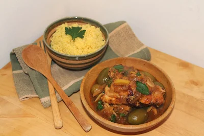 Serving bowls of chicken with preserved lemons and olives along with a bowl of saffron couscous.