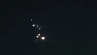 UFO breaks up over the UK with the pieces flying away.