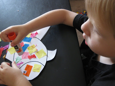 Evan made a rainbow fish using a fish outline, cut up tissue paper, 