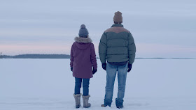a woman and a man stand in the snow in minnesota