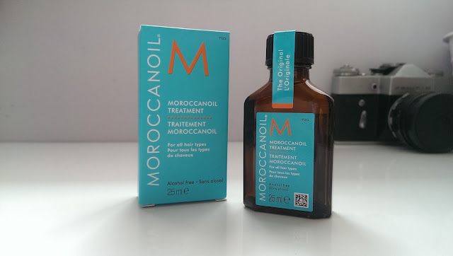 A bottle of Moroccanoil treatment next to its box