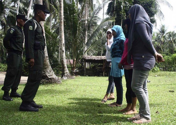 Sharia police give advice to women caught wearing tight pants during a 