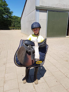 Grand daughter carrying her saddle. Courtesy of Lis Vaessen