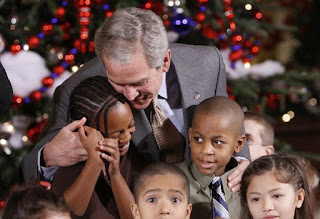 President George W. Bush embraces a group of youngsters