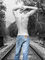 blonde boy on railway tracks in blue jeans