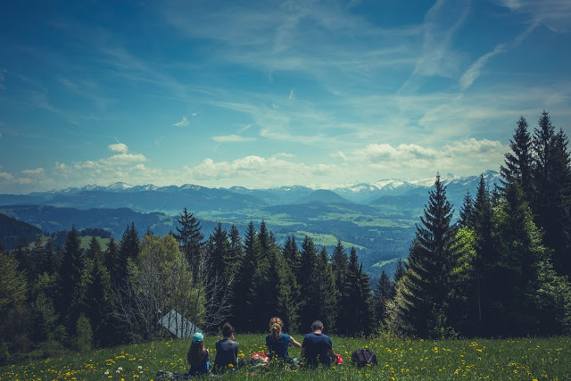 Family dining outdoors with a mountain view