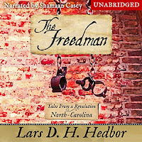 Audiobook cover of The Freedman: Tales From a Revolution - North-Carolina. A pair of manacles hang in front of a brick wall.