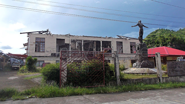 The UP Oblation monument with a Yolanda devastated building of UP-SHS in the background, Palo Leyte