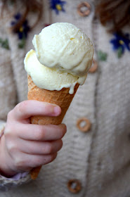 Zwei Kugeln Pastinaken-Birnen-Eis liegen in einem Eisstanitzel und werden von einer Kinderhand in die Kamera gehalten.